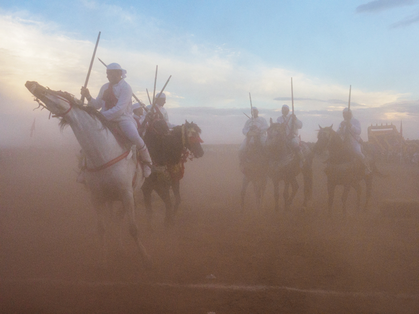 Jinetes marroquíes durante una exhibición de Tbourida con caballos al galope y descarga de pólvora.