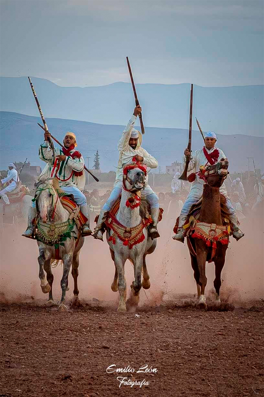 Jinetes marroquíes durante una exhibición de Tbourida con caballos al galope y descarga de pólvora.